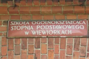 Szyld nad wejściem do szkoły podstawowej w Wiewiórkach