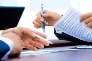 Dłonie z długopisem pracujące nad dokumentami