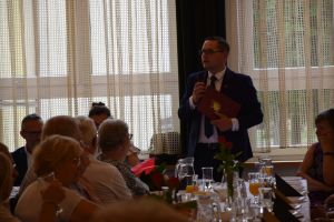grupa osób przy stołach podczas uroczystości