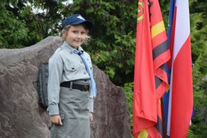 Harcerka stojąca pod pomnikiem