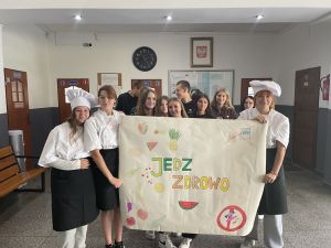 Grupa uczniów z plakatem "jedz zdrowo"