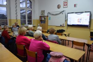 Seniorzy słuchający wykładu o wpływie aktywności fizycznej na samopoczucie, porad dietetyka i o znaczeniu profilaktyki...