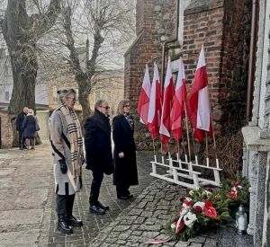 Marek Markowski Przewodniczący Rady Powiatu, Gizela Pijar Wicestarosta, Anna Wetzel Sekretarz Powiatu składający kwiaty pod...