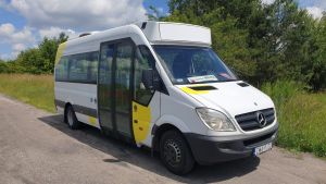 Biało-żółty autobus na drodze.