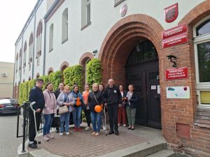 Uczestnicy Warsztatu Terapii Zajęciowej w Wąbrzeźnie przez budynkiem Starostwa Powiatowego w Wąbrzeźnie.