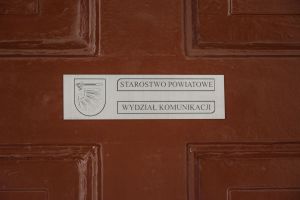 Tabliczka na drzwiach "STAROSTWO POWIATOWE WYDZIAŁ KOMUNIKACJI"