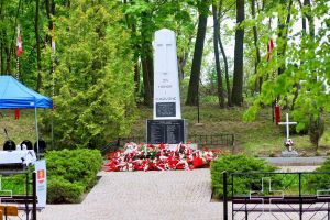 Złożone kwiaty pod pomnikiem na cmentarzu wojennym w Książkach