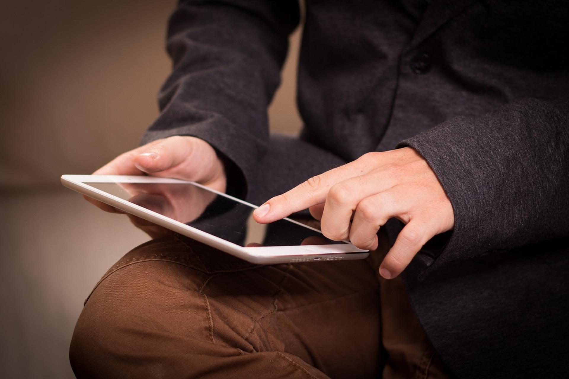 Dłonie wskazujące na tablet